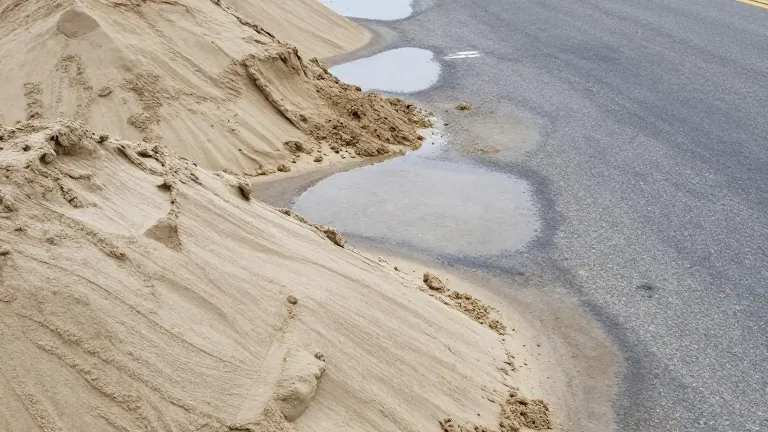 Illustration for: Long Beach crews build sand berms as high tides batter coastline
